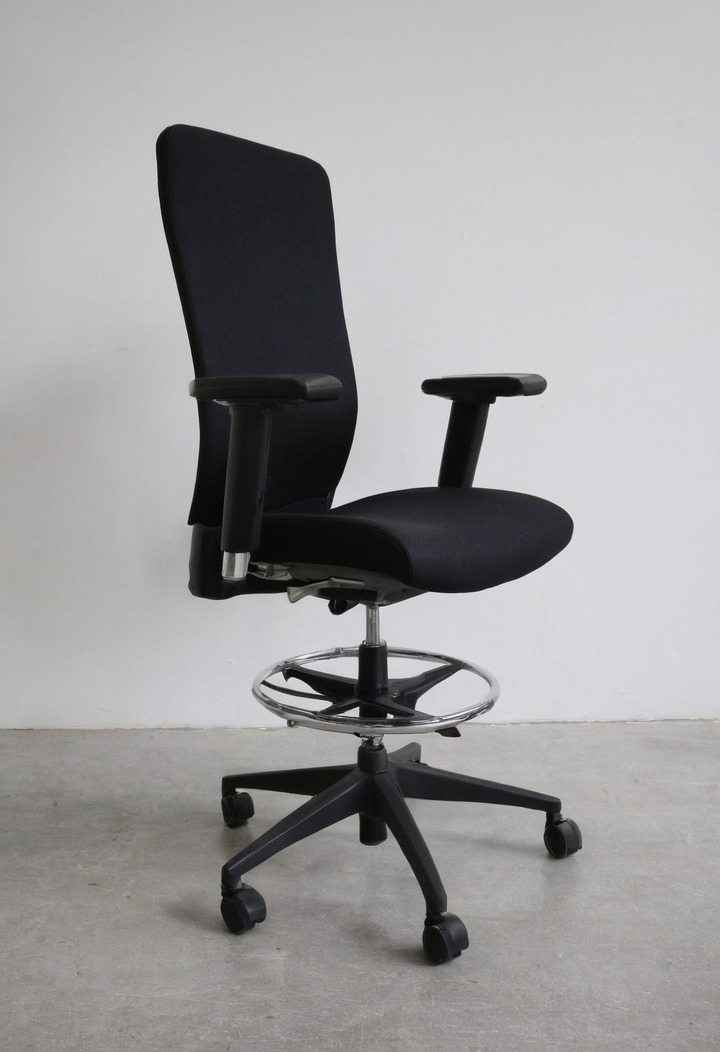 A grey fabric office chair photographed exactly from the side against a plain white wall, showing seat height, seat depth and armrest height.