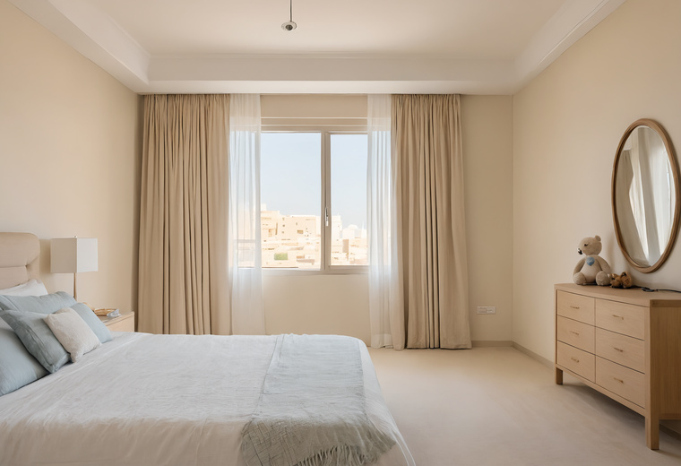 Bedroom in a Dubai apartment with pale bedding, a wooden chest of drawers and long curtains framing a window
